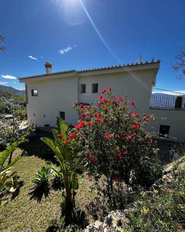 a house with red flowers in front of it at Cortijo Privilegio in Lanjarón