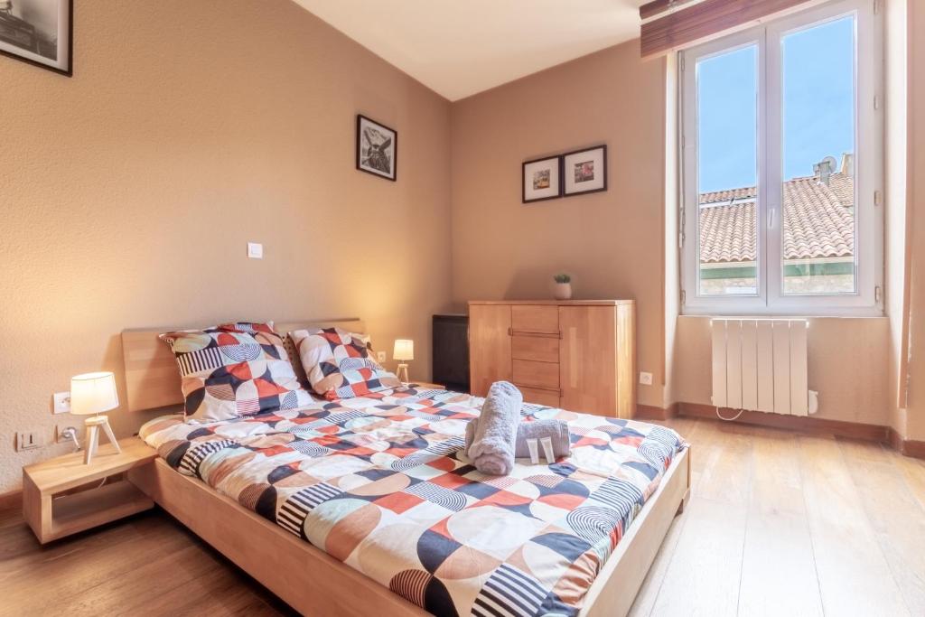 une chambre avec un lit avec un animal en peluche dessus dans l'établissement Hypercentre - Proche Parking Gratuit - Fibre - Calme, à Narbonne