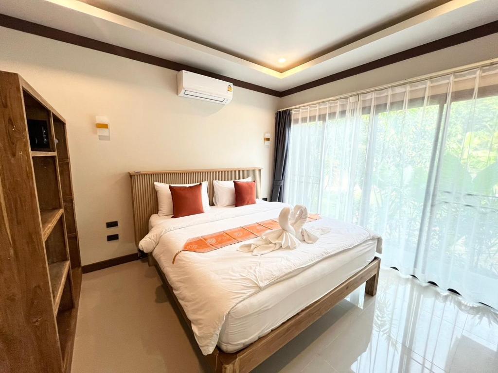 a bedroom with a bed and a large window at Bang Po Hut in Ban Bang Po