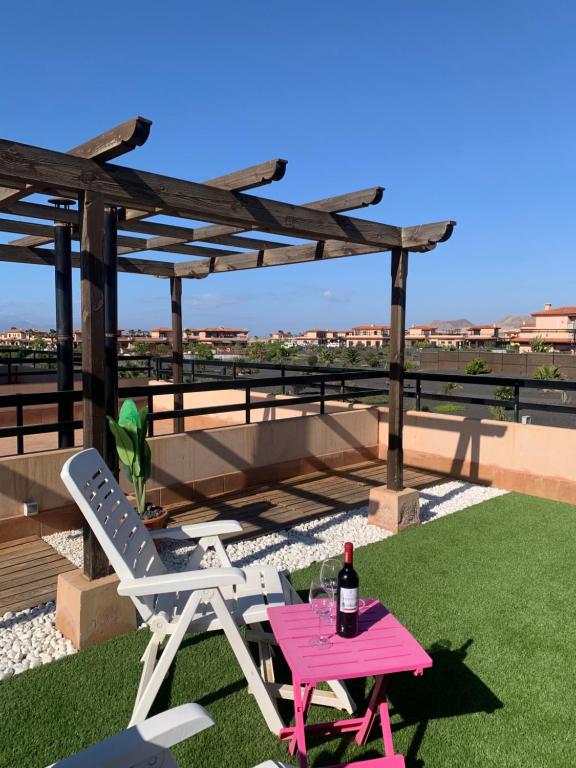 a picnic table and a chair and a bottle of wine at Villa Punta Calma in Majanicho