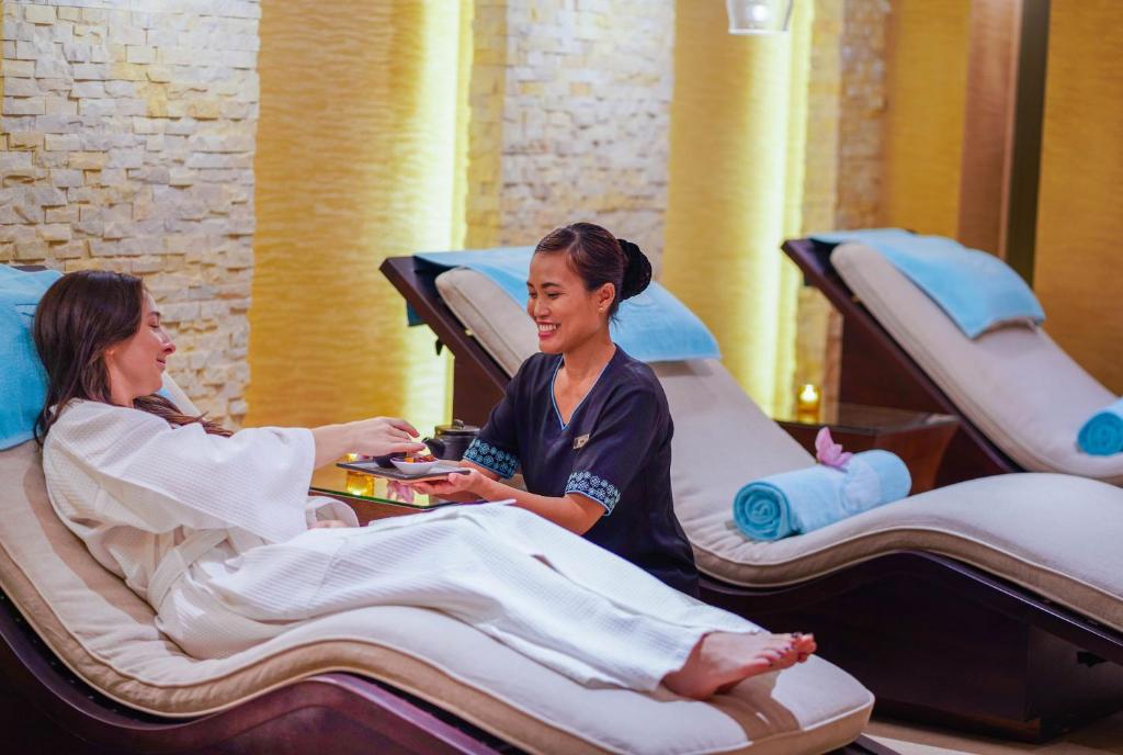 two women sitting at a table in hospital beds at Beach Rotana - Abu Dhabi in Abu Dhabi