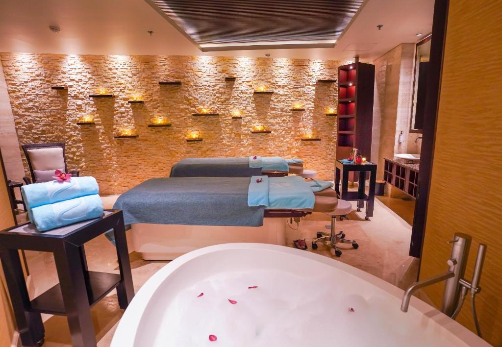 a bathroom with a bed and a bath tub at Beach Rotana - Abu Dhabi in Abu Dhabi