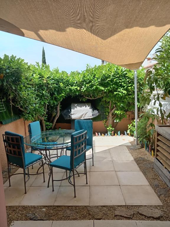 d'une terrasse avec une table et des chaises en verre. dans l'établissement La Bulle temporelle d'Hélène, à Saint-Cyprien