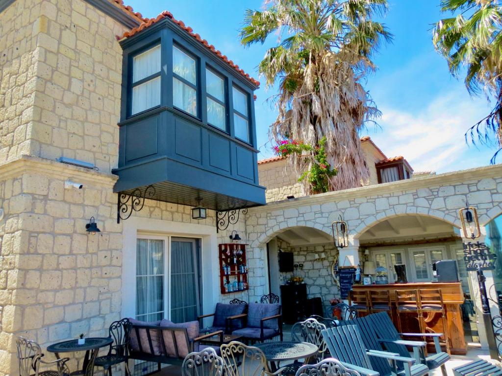 a building with a blue window and tables and chairs at Fedora Otel Alaçatı in Alaçatı