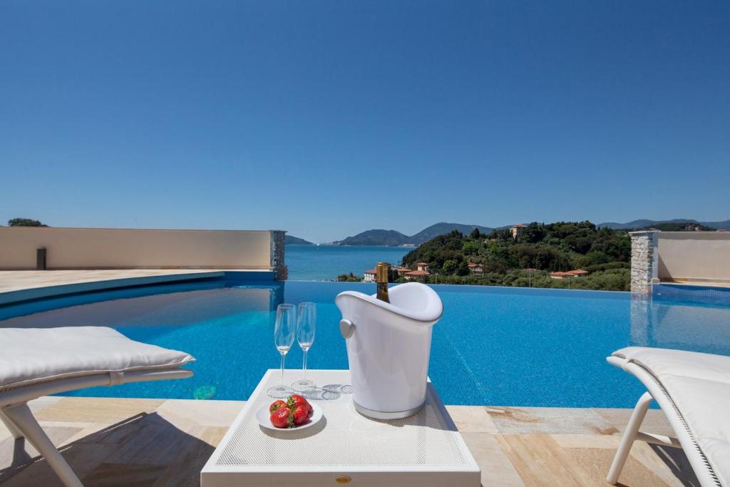a villa with a pool and a table with wine glasses at La Vista Azzurra in Lerici