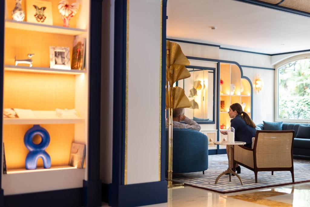 a woman sitting in a chair in a room with a mirror at Grand Hotel San Pietro Taormina in Taormina
