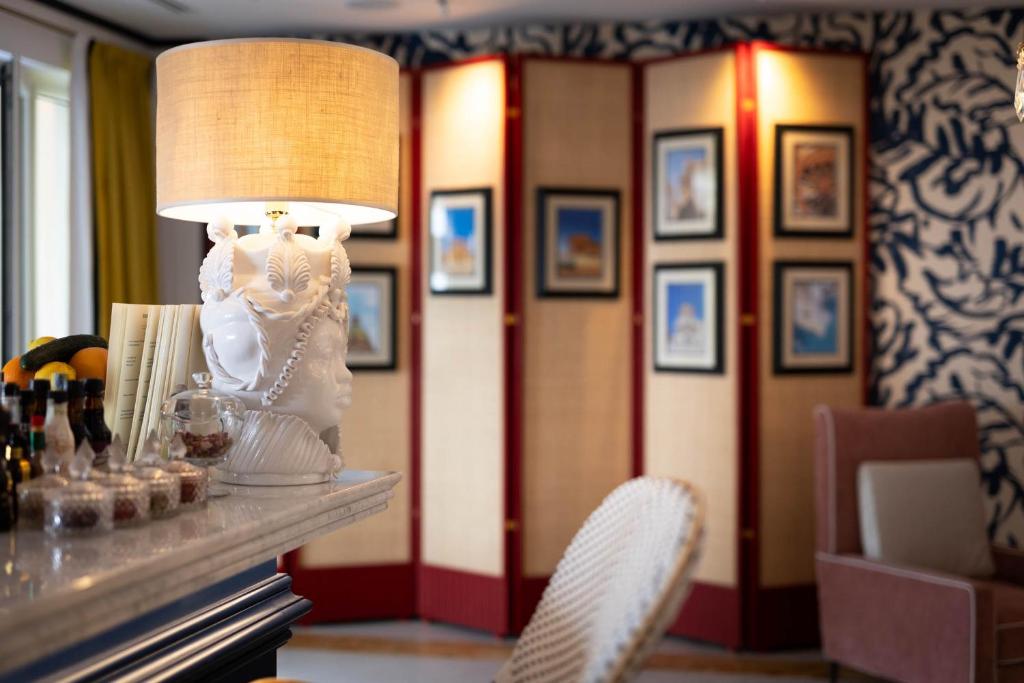 a room with a table with a lamp and chairs at Grand Hotel San Pietro Taormina in Taormina