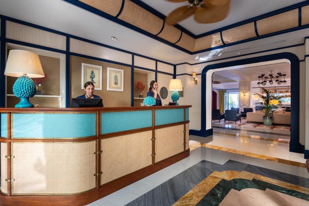 two people standing at a bar in a hotel lobby at Grand Hotel San Pietro Taormina in Taormina