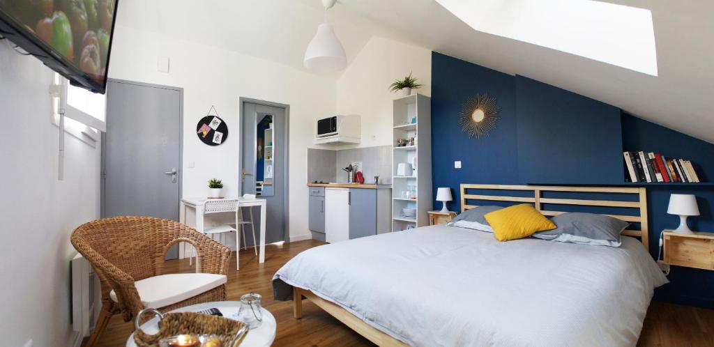 a bedroom with a bed and a blue accent wall at La Résidence des 53 in La Roche-sur-Yon