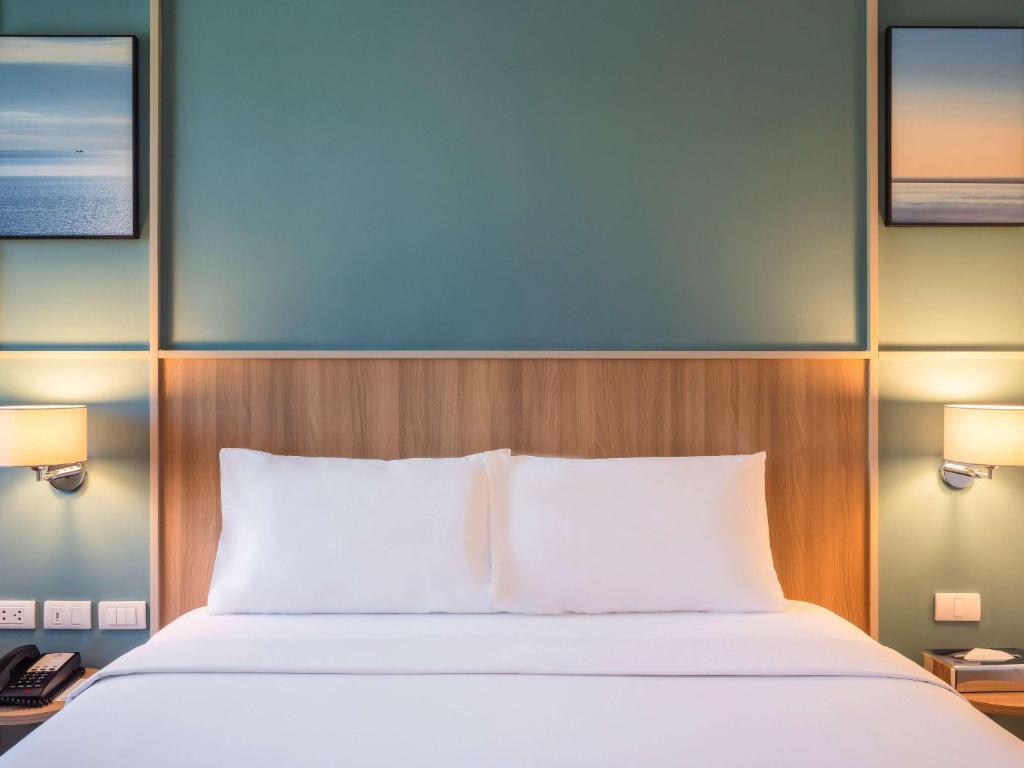 a bedroom with a bed and two lamps and a phone at Ibis Phuket Patong in Patong Beach