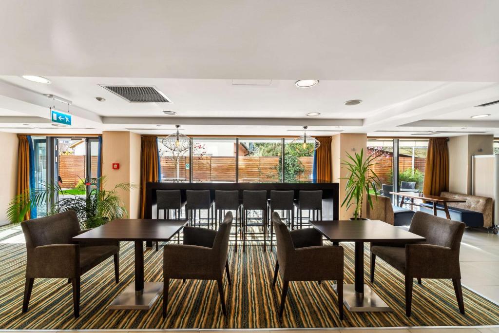 a meeting room with two tables and chairs and windows at Hampton by Hilton Cluj-Napoca in Cluj-Napoca