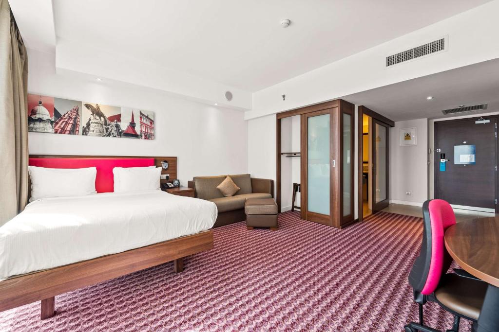 a hotel room with a bed and a desk at Hampton by Hilton Cluj-Napoca in Cluj-Napoca
