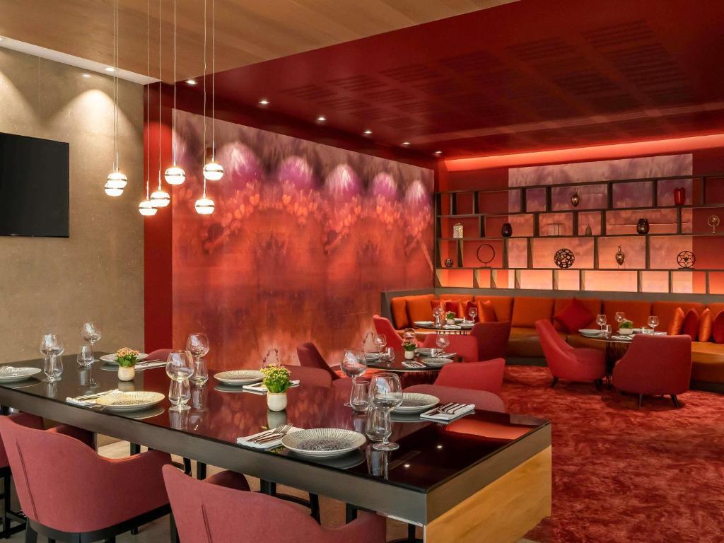 a dining room with a table and red chairs at Novotel Istanbul Bosphorus Hotel in Istanbul