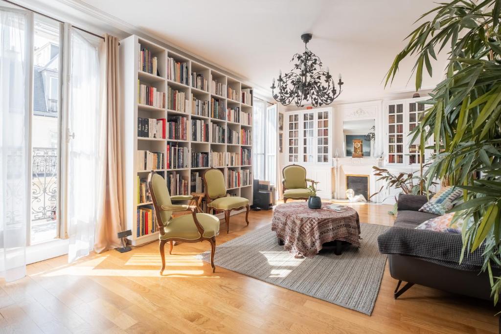 - un salon avec une table et des étagères dans l'établissement Veeve - Literary Radiance, à Paris