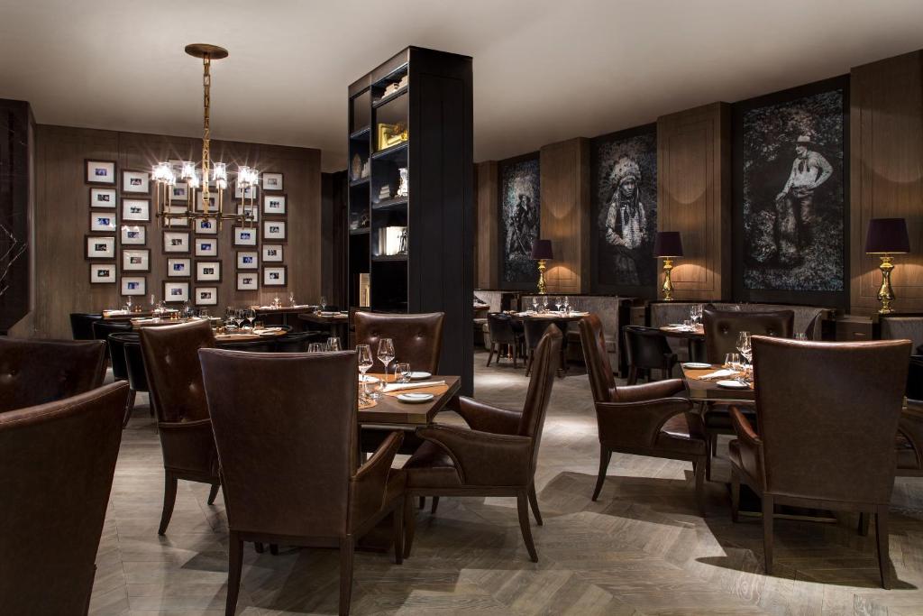 a restaurant with tables and chairs and a chandelier at Beach Rotana - Abu Dhabi in Abu Dhabi