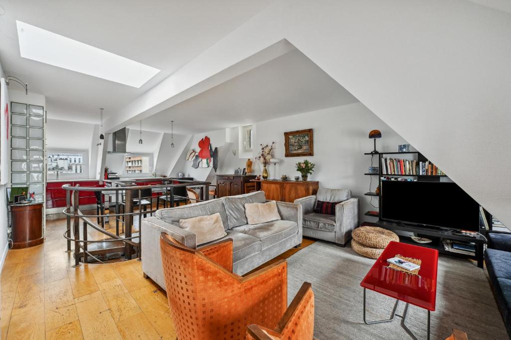 un salon avec un canapé et une télévision dans l'établissement Veeve - The Spiral Centrepiece, à Paris