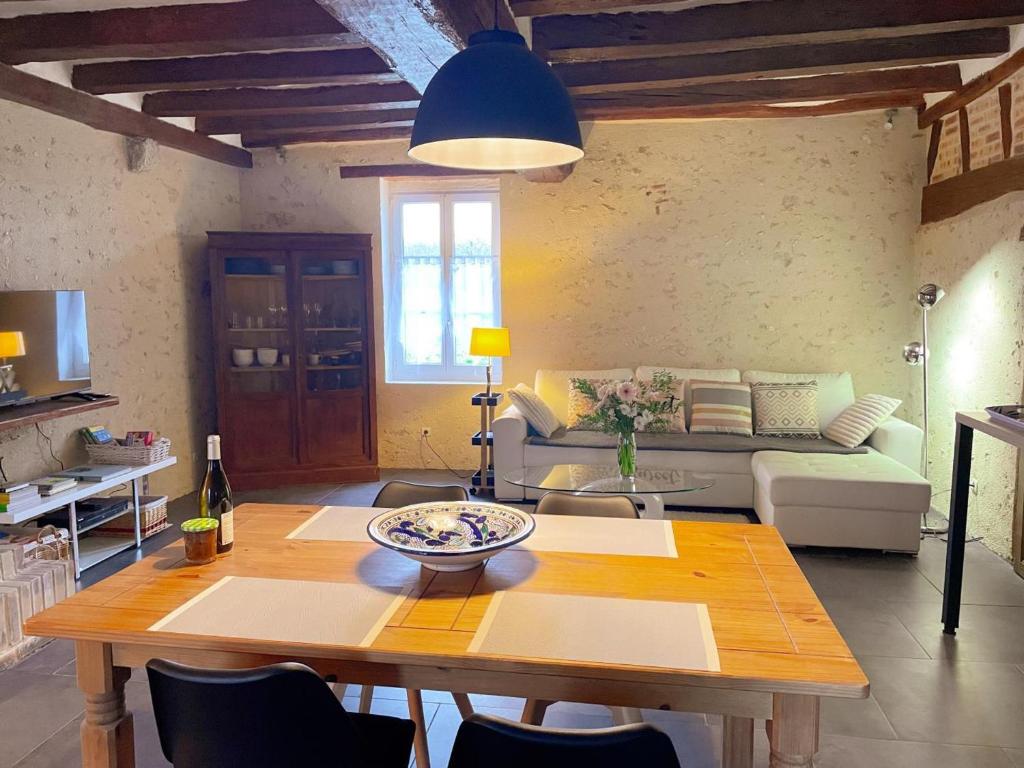 ein Wohnzimmer mit Tisch und Couch in der Unterkunft Gîte tout confort avec grand jardin, cheminée, clim et WIFI, proche châteaux de la Loire et ZooParc de Beauval - FR-1-491-400 in Le Controis En Sologne