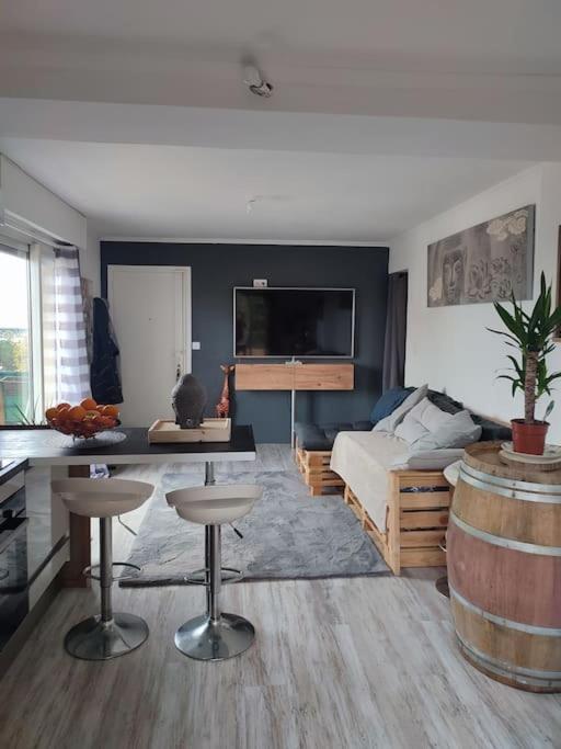 - un salon avec un lit et une table avec des tabourets dans l'établissement Appartement dans immeuble de Ville, à Saint-Laurent-du-Var