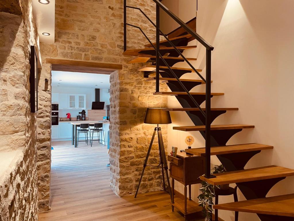 - un escalier en colimaçon dans une chambre dotée d'un mur en briques dans l'établissement Gîte chez René, à Fresville