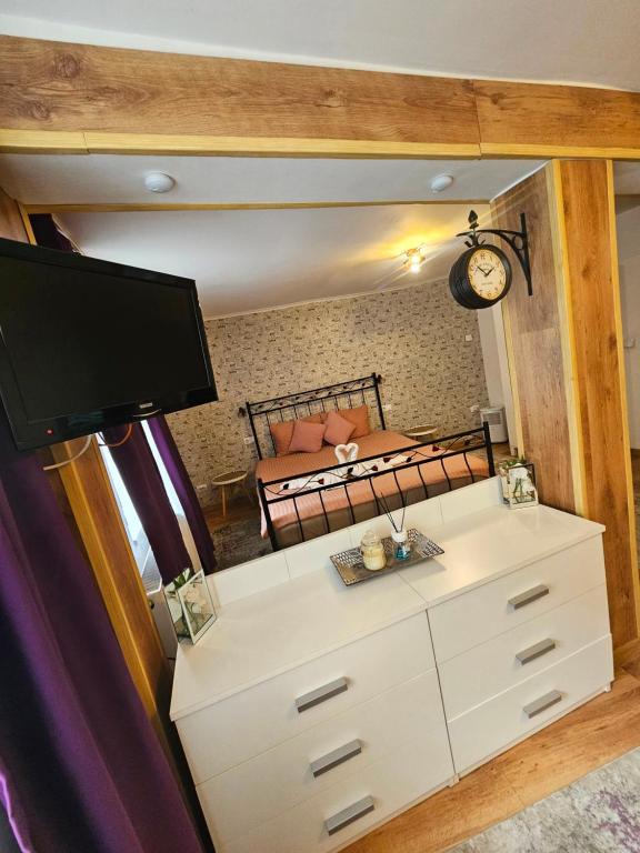Un dormitorio con una cama, una cómoda y un espejo. en Tudor Residence Sibiu, en Sibiu