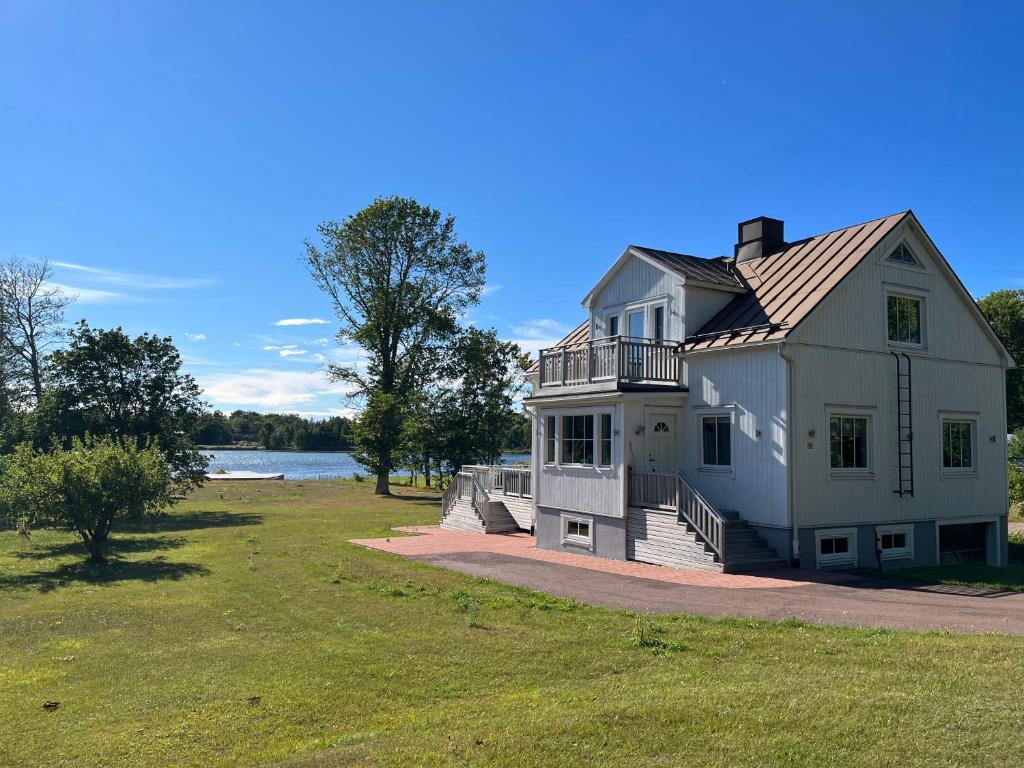 a large white house on the side of a lake at House by the ocean in Mariehamn in Mariehamn