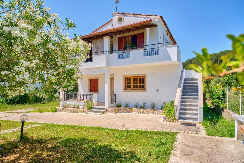 a white house with stairs in front of it at Kodelo summer house in Corfu