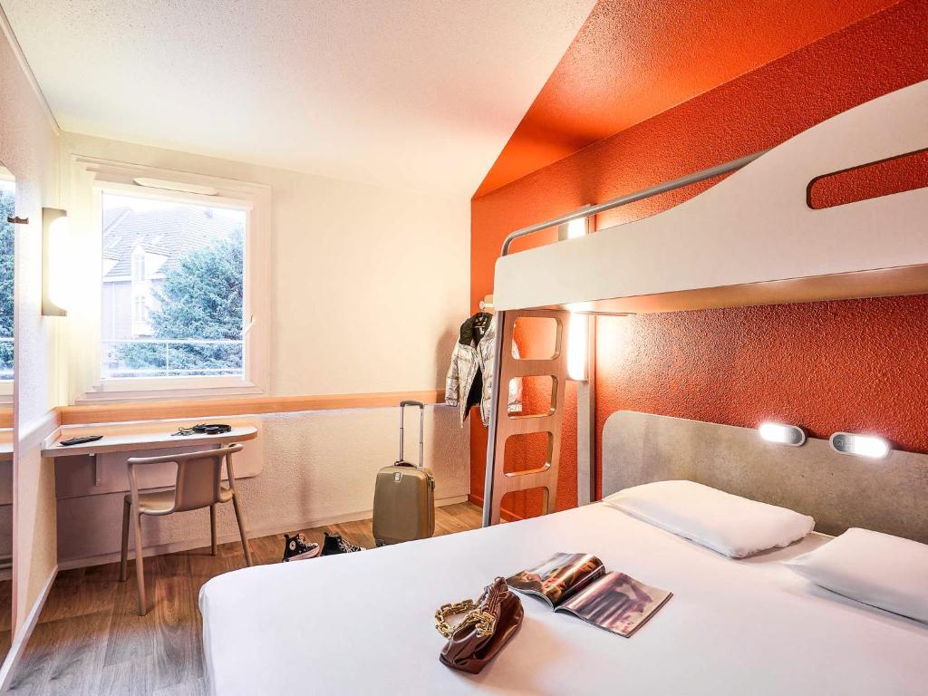 une chambre avec un lit et un bureau et un lit superposé dans l'établissement Ibis Budget Lille Gares Vieux-Lille, à Lille