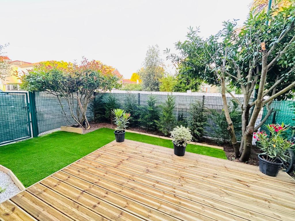 a garden with a wooden deck and plants at Logement entier proche de Paris in Croissy-sur-Seine