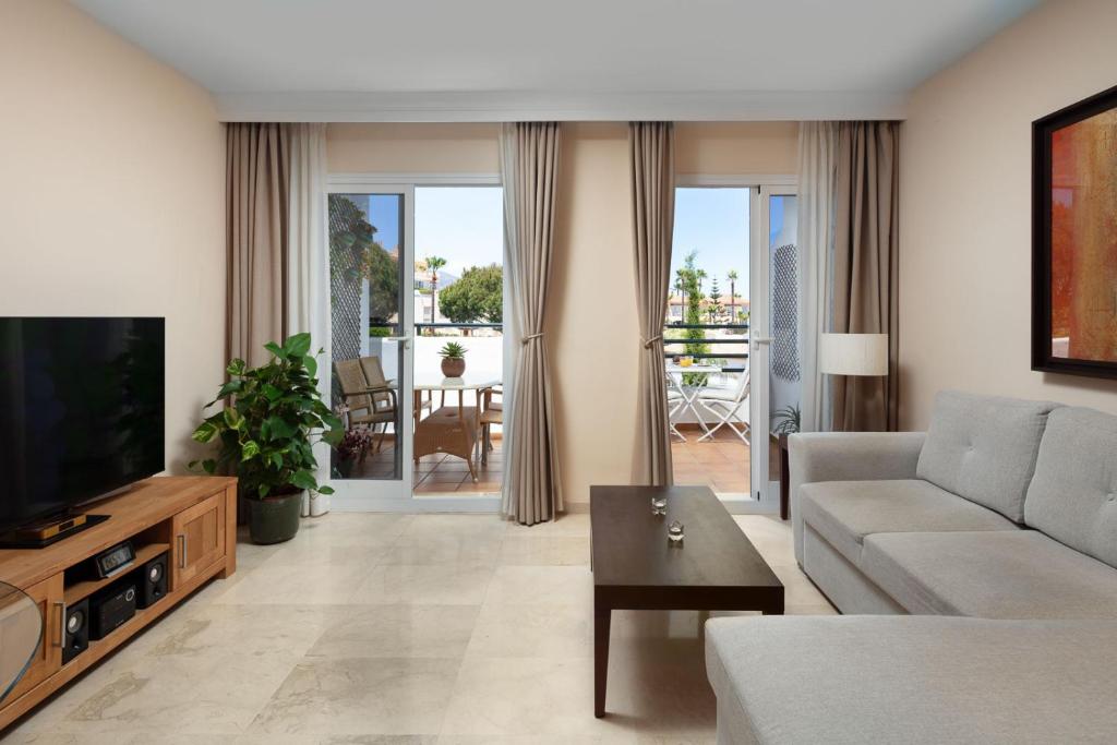 salon z kanapą i telewizorem w obiekcie Garden & Sea Apartments Mijas Costa & Fuengirola w mieście Mijas Costa