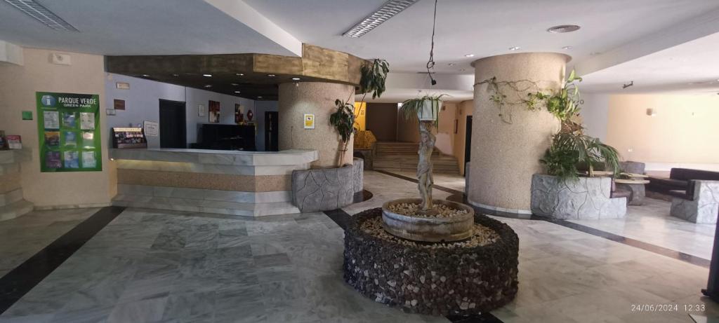 a lobby with a potted plant in the middle of a building at Apartamentos Green Park Tenerife in San Miguel de Abona