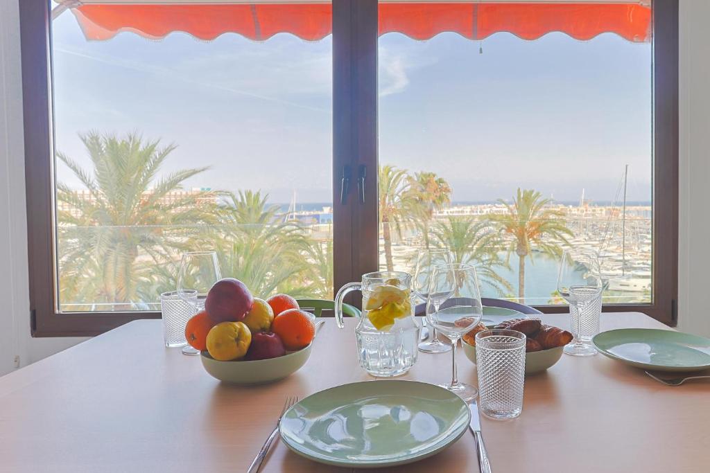 Una mesa con cuencos de fruta sobre una mesa con vistas. en Casas 349h Explanada Alicante, en Alicante