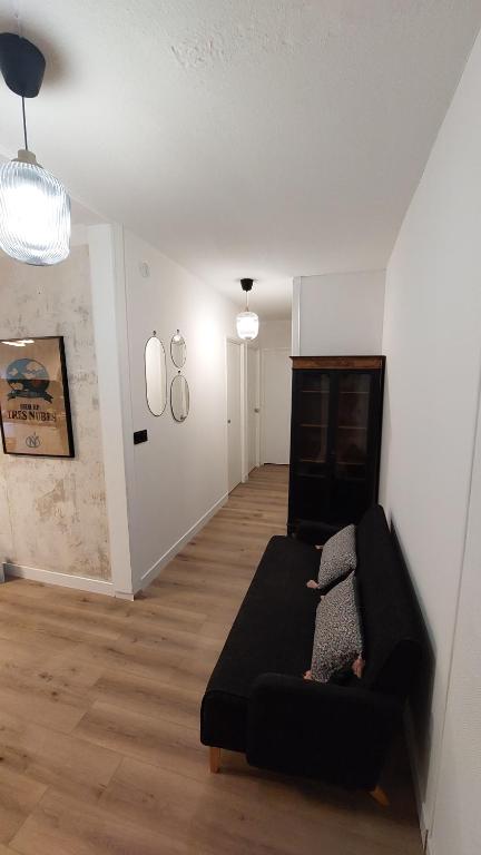 un salon avec un canapé noir dans une pièce dans l'établissement Appartement Montpellier avec piscine, à Montpellier