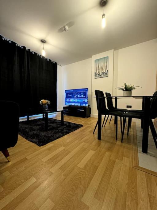 Hotel Two Bedrooms Flat In Stratford, a living room with a piano and a television at Two Bedrooms Flat In Stratford in London