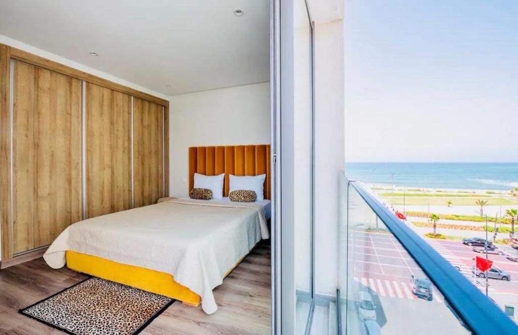 a bedroom with a bed and a balcony with the ocean at Atlantic Suite View 1 in Casablanca