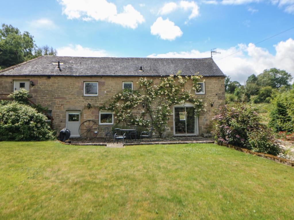 an old stone house with a large yard at Dale View Cottage in Bakewell