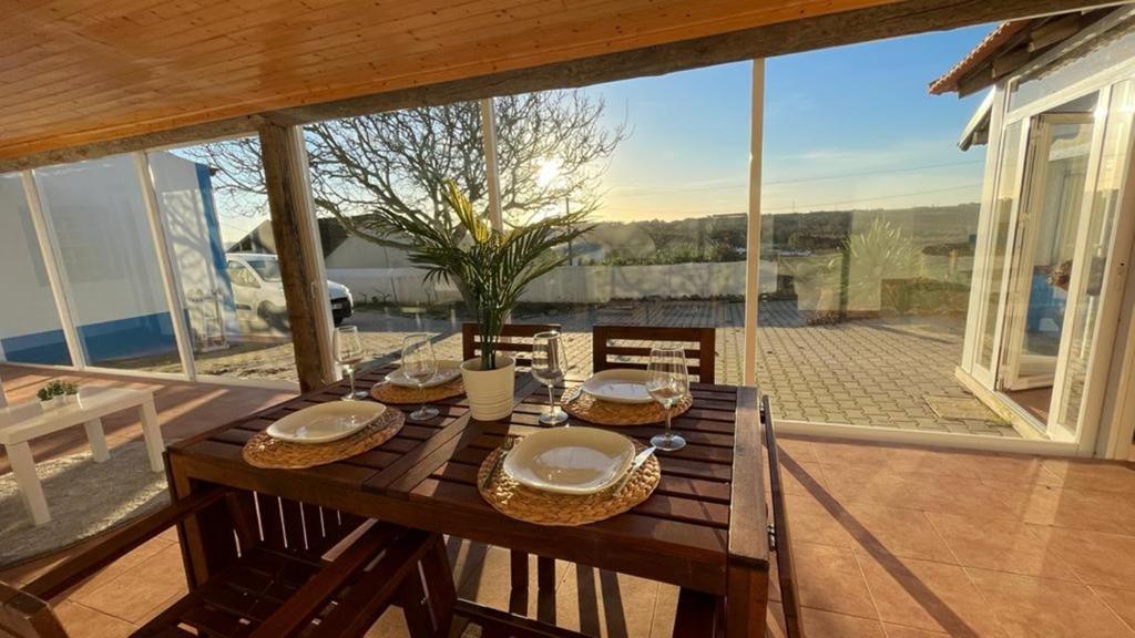 a wooden table with plates and napkins on top of it at The Sunset Spot in São Bartolomeu