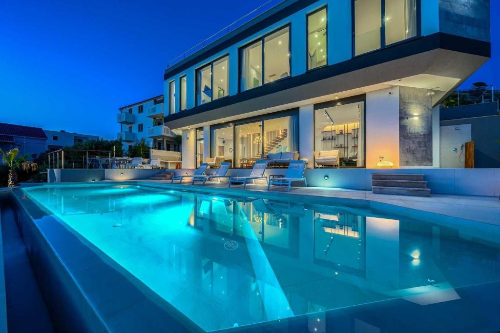 a swimming pool in front of a house at night at Villa Allina, 5-Bedroom Villa with Panoramic Views, Heated Pool in Podglavica