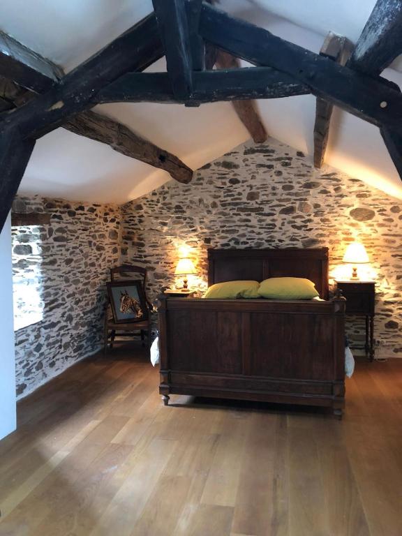 une chambre avec un lit dans un mur de pierre dans l'établissement Havre de paix, à Mas-Cabardès