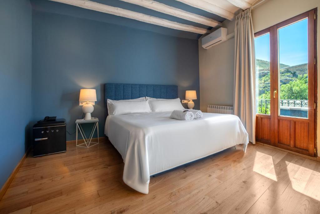 a bedroom with a white bed and a large window at Hotel-Boutique by Gonzalo Sesma in Cervera del Río Alhama