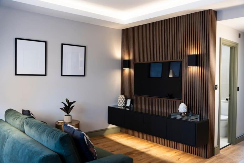 a living room with a couch and a television at The Verdant Apartment in Harrogate