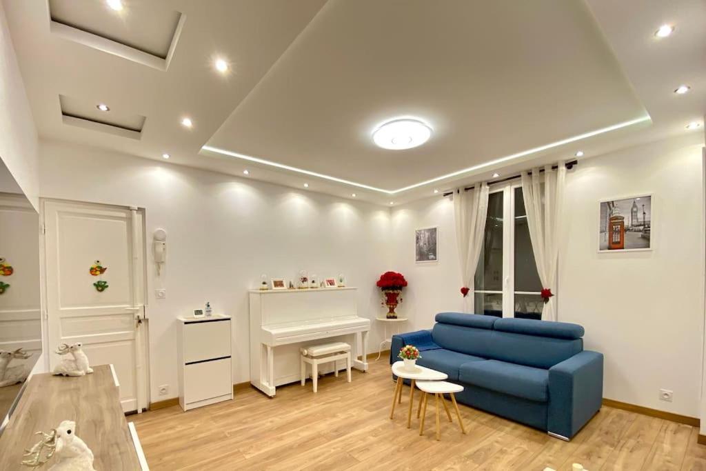 un salon avec un canapé bleu et une table dans l'établissement Paris cosy apartment 80m2, à Suresnes