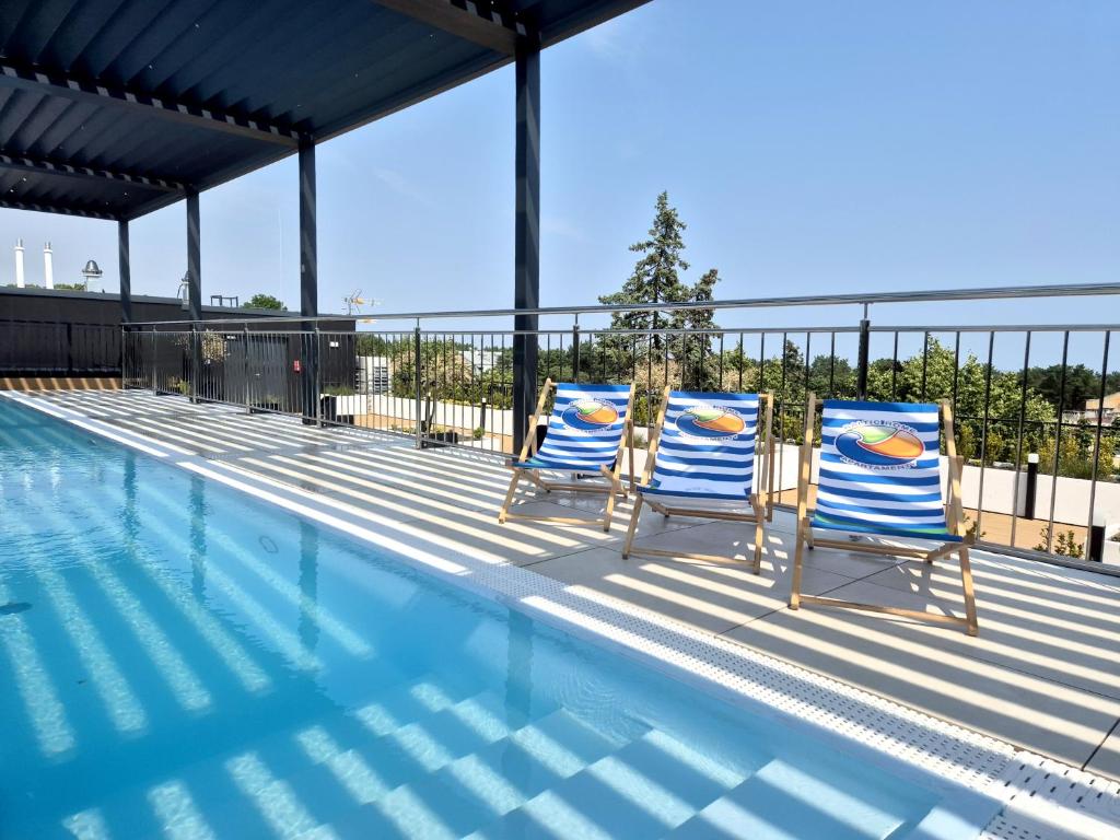 two chairs sitting next to a swimming pool at Seaside Garden by Baltic Home Świnoujście in Świnoujście