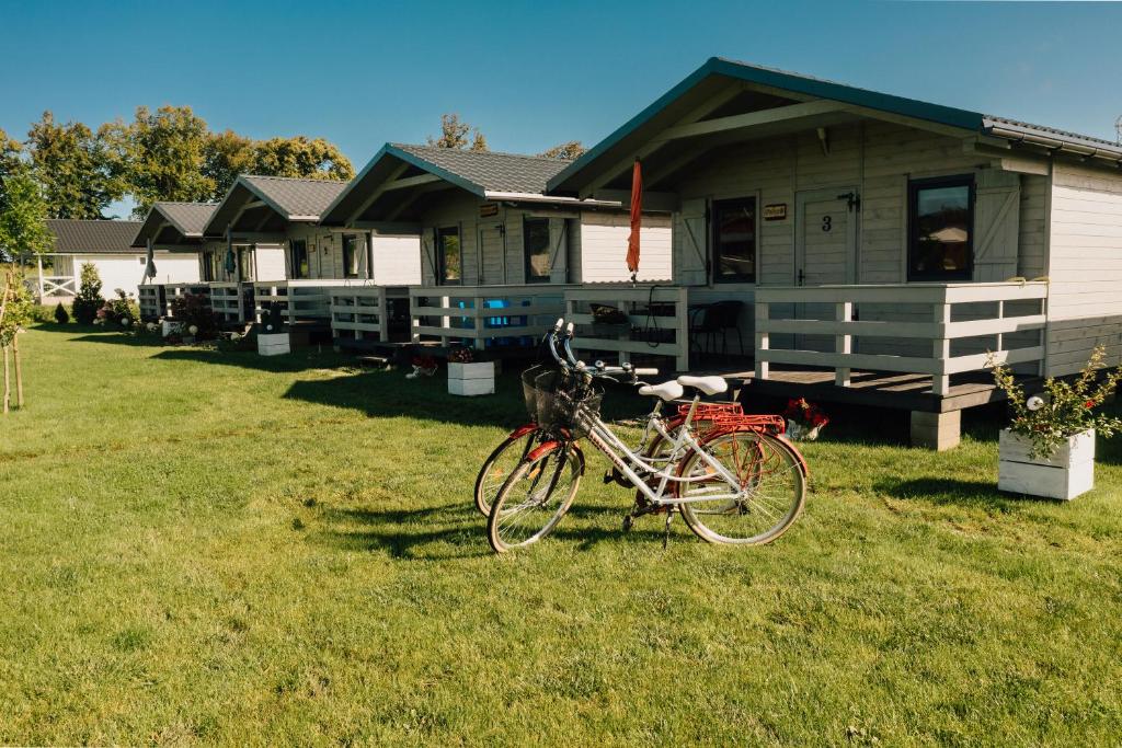 a bike parked in front of a house at Malinowe Zacisze - Domek żółty in Rusinowo