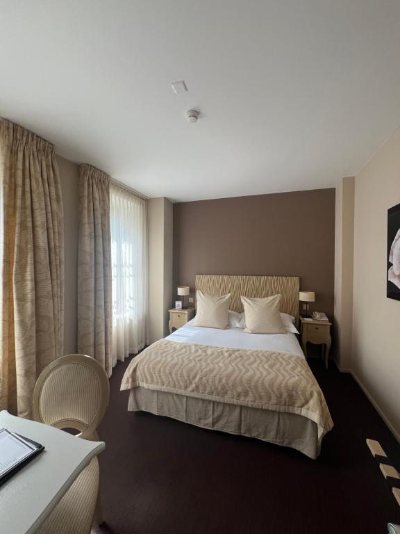 Postel nebo postele na pokoji v ubytování Hostellerie Le Petit Manoir