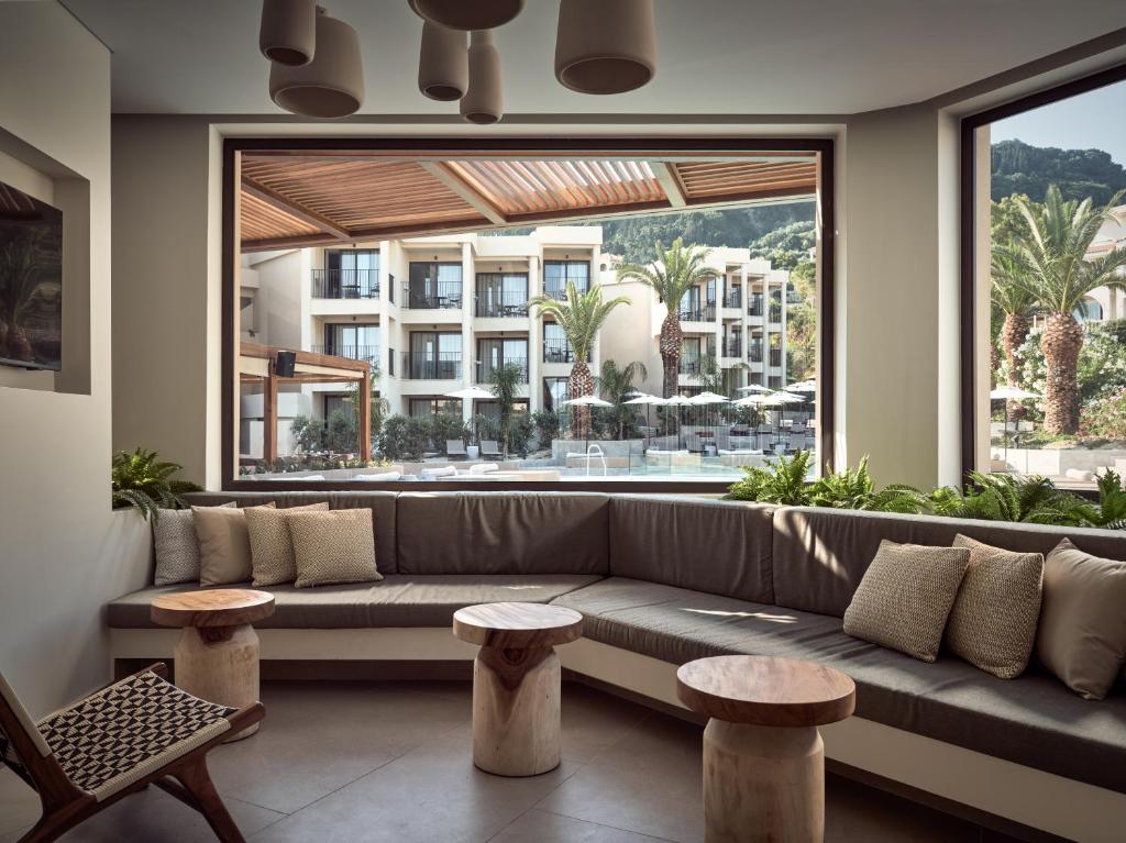 a living room with a couch and a large window at Admiral De Luxe in Zakynthos