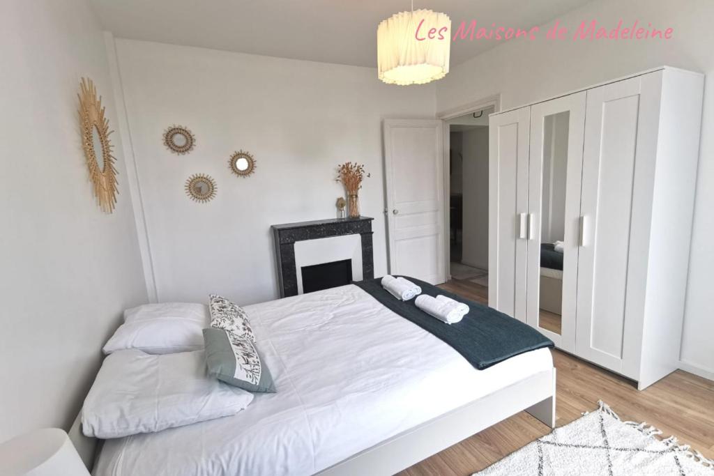 une chambre blanche avec un lit et une cheminée dans l'établissement Nouveau - Au bout du quai, à Nantes