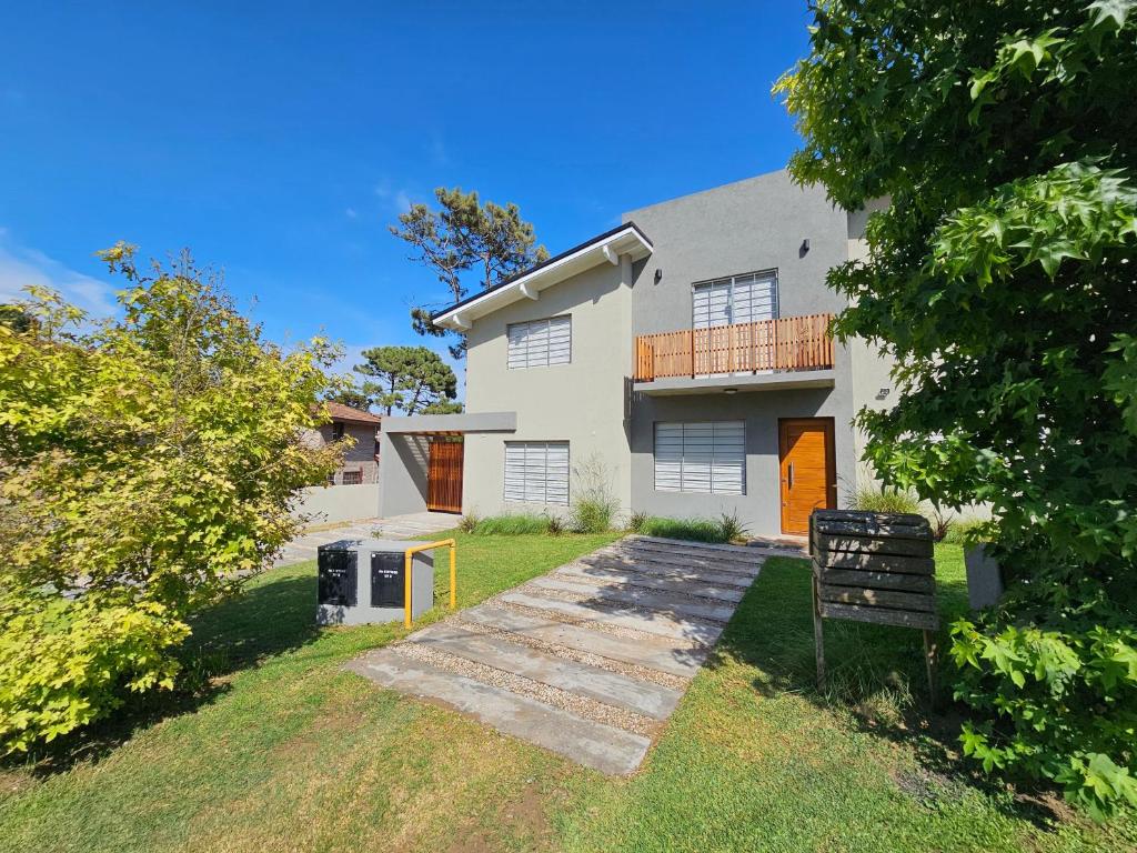 a large white house with a yard at Dúplex Familiar Av 5 y Paseo 117 in Villa Gesell