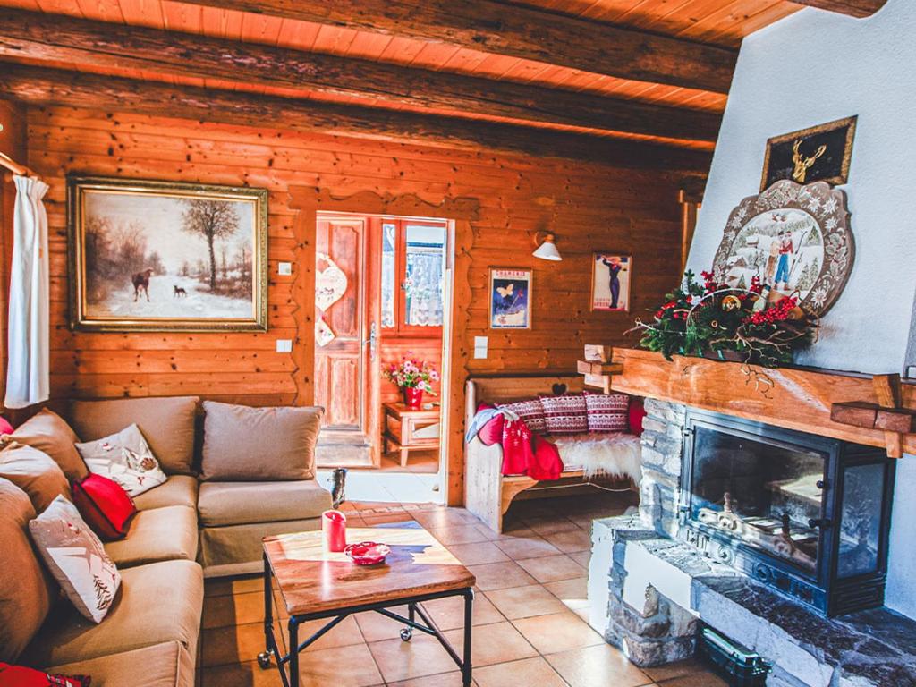 un salon avec un canapé et une cheminée dans l'établissement Chalet aux Gets avec Wi-Fi, cheminée, parking privatif, barbecue, proche pistes - FR-1-671-7, aux Gets