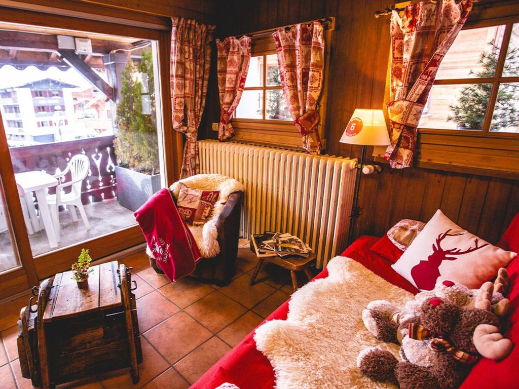 a living room with a couch and a table and windows at Appartement au centre Les Gets, 3 étoiles, 3 pers, proche télécabines et école de ski - FR-1-671-6 in Les Gets