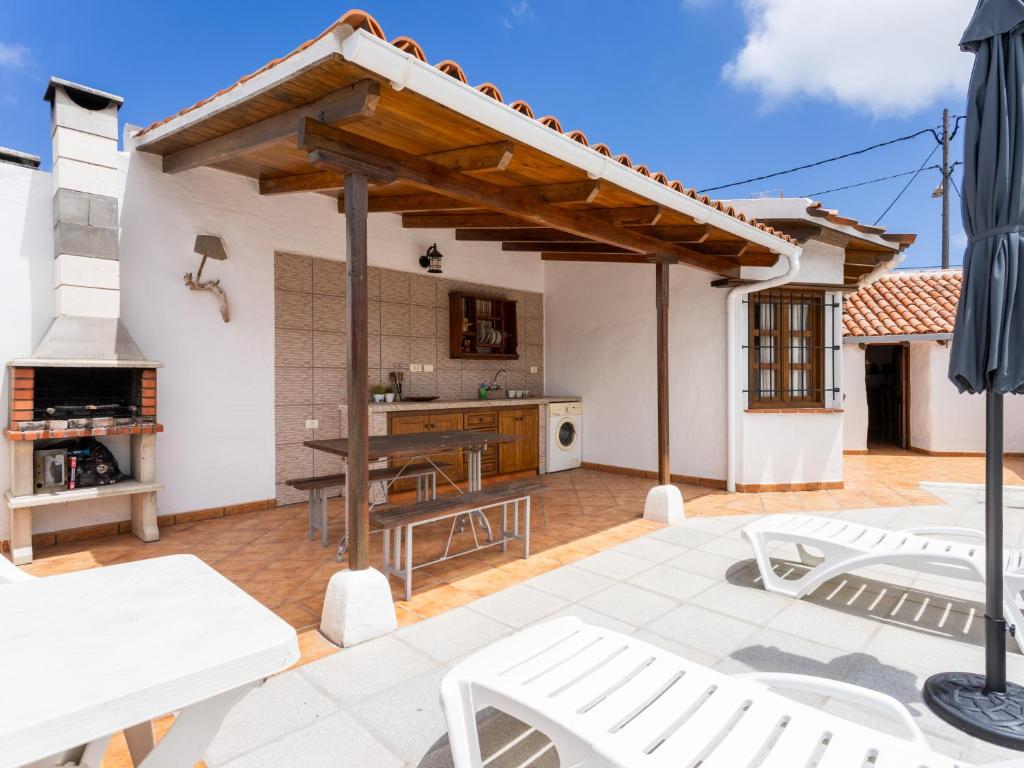 a patio with a table and chairs and a house at Live Arico El Cortijo Casa Rural con Solarium y Terraza in Arico Viejo